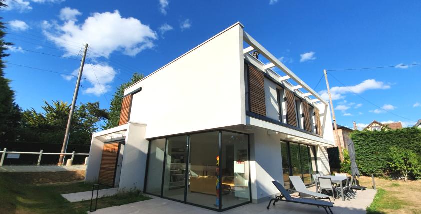Vue sud-ouest sur jardin. Le séjour est largement vitré, sans poteau d'angle.