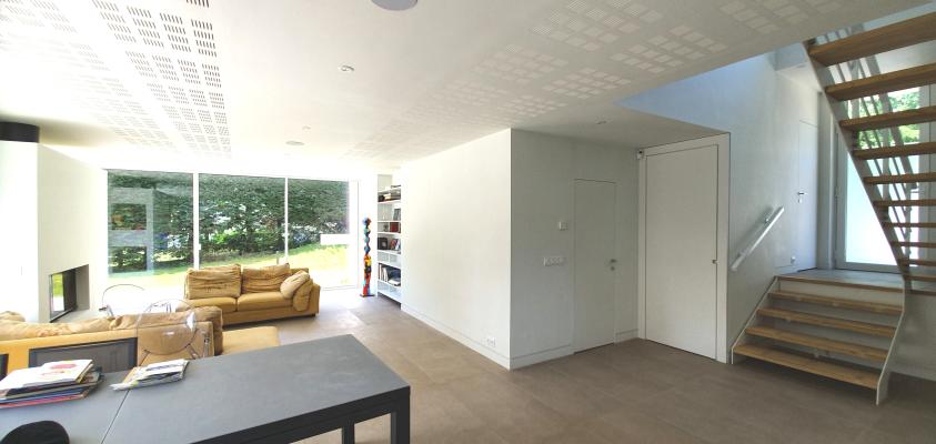 Séjour en rez-de-jardin avec cheminée et bibliothèque intégrées, entrée à mi-niv