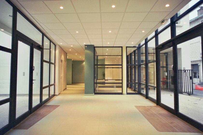 Le hall d’accueil et préau des enfants, le secrétariat vitré, et à l'extérieur, 
