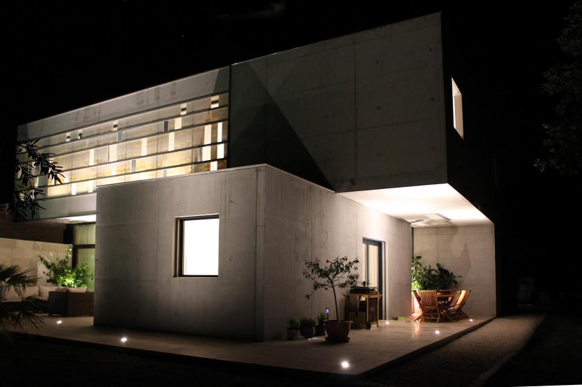 vue de la façade principale de nuit avec la paroi d'onyx translucide 