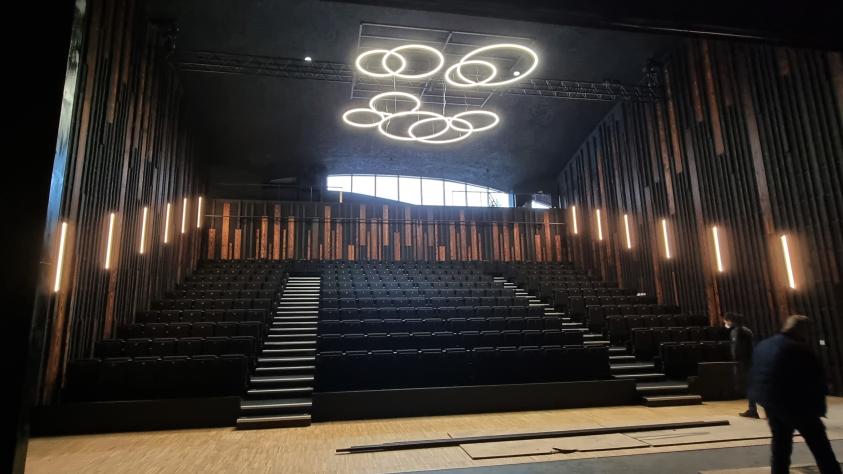 La salle de spectacle, gradins dépliés. bois brûlé