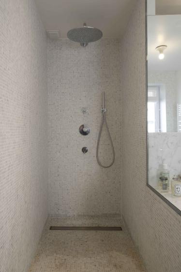 Salle-de-bain dont les murs sur revêtus de mosaïques de "marbre de Carrare vieil