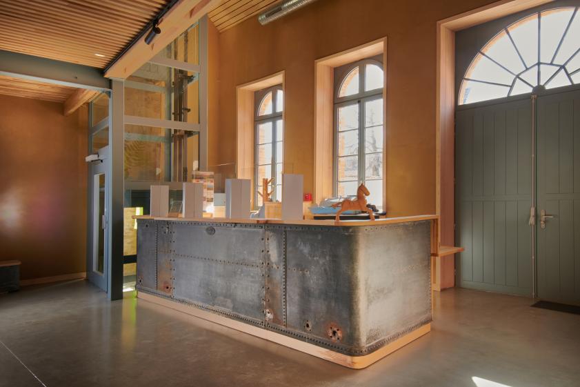 Récupération et transformation de la cuve de la brasserie en banque d'accueil.