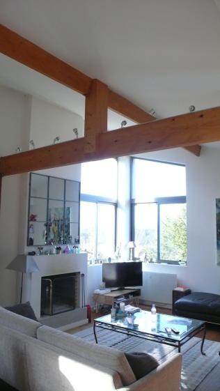 le Salon: la cheminée, la charpente en bois et les chassis alu d'angle pour la v
