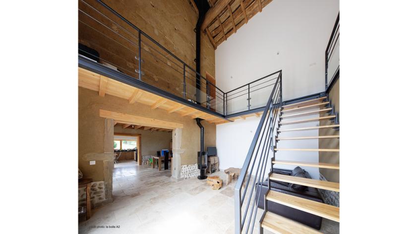 Vue de la pièce de vie avec enduits terre, planchers bois et escalier et structu