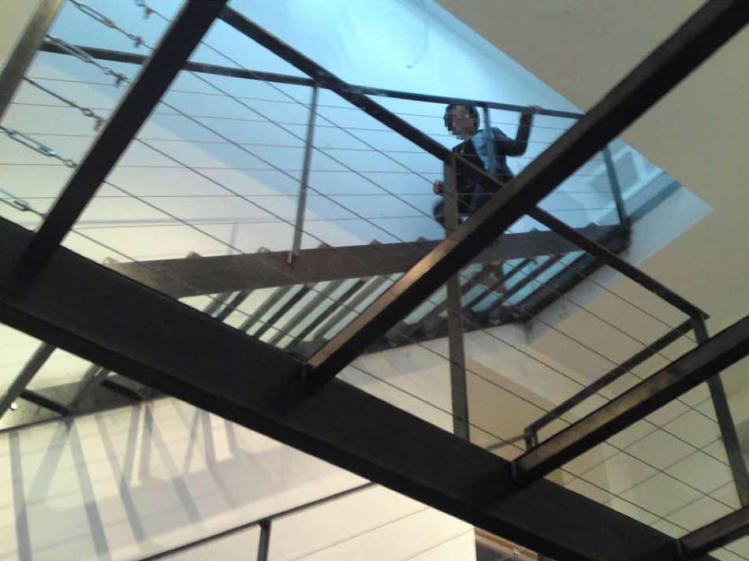 Vue sur l'escalier en verre, puit de lumière, colonne vertébral de la maison.