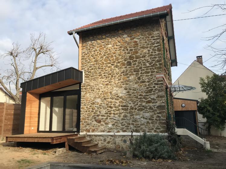 Le pignon existant et l'extension qui entoure la maison