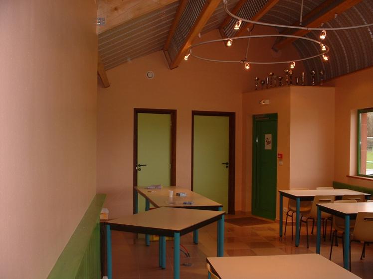 Vue de l'intérieur du club house vers les portes, local technique, toilettes et 