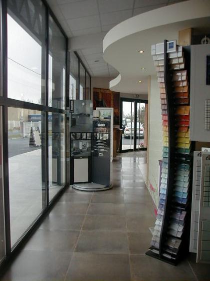 Intérieur du bâtiment avec vue sur un ilôt de présentation des carrelages avec f
