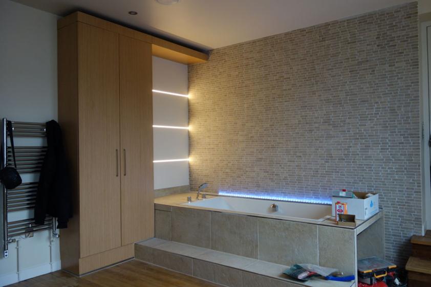 Salle de bain avec matériaux nobles mis en valeur par un éclairage intégré 