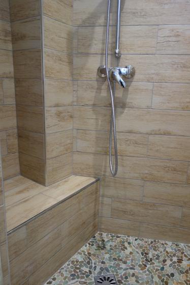 Douche pourvue d'un banc avec des matériaux nobles