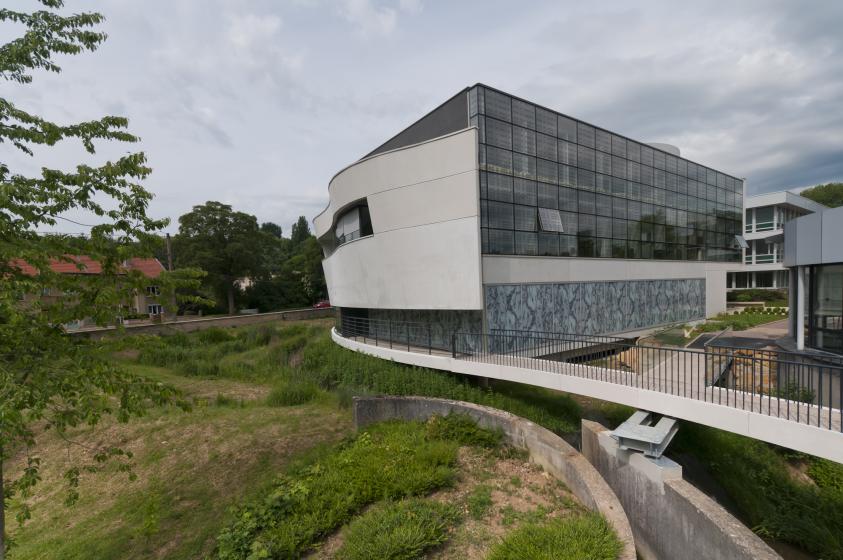 le bâtiment et sa passerelle surplombant le ruisseau