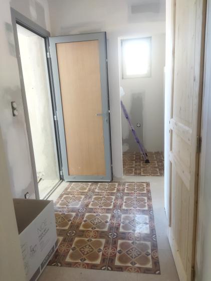 Travaux de finition en cours : pose du panneau de porte et peinture