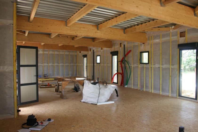 Pose de l'OSB sur le pare-vapeur. Les murs sont isolés avec de la laine de bois.