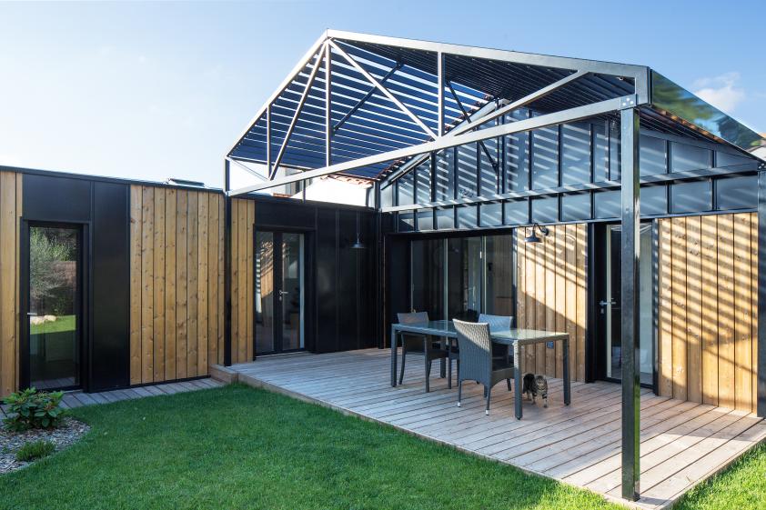 Au cœur de la parcelle, une pergola métallique vient protéger la terrasse.