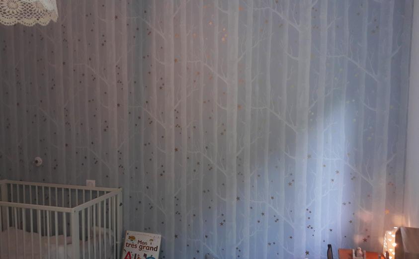 La chambre d'enfant, animée par un papier peint Arbres et Etoiles