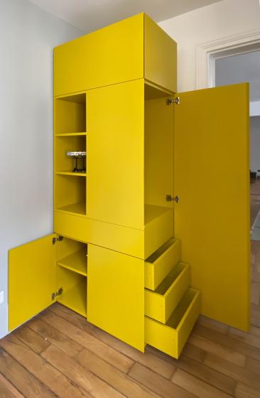 meuble transformer qui se déploie tel un couteau suisse offrant des rangements et un bureau caché déployable