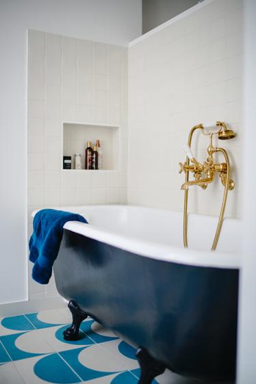 Espace bain avec baignoire sur pieds, robinetterie en laiton style rétro et, car