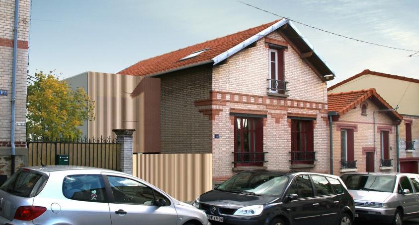 Rue de briques et cube de bois : extension d'une maison existante