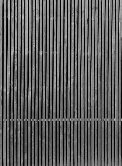 Vue sur la texture contemporaine du bardage posé à claire voie, le bois étant na
