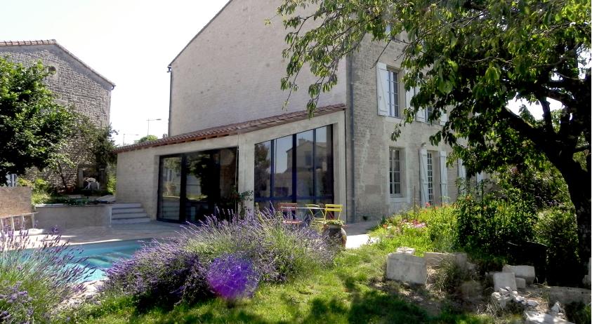 L'extension de la maison en pierre est constituée d'une veranda (partie salle à 