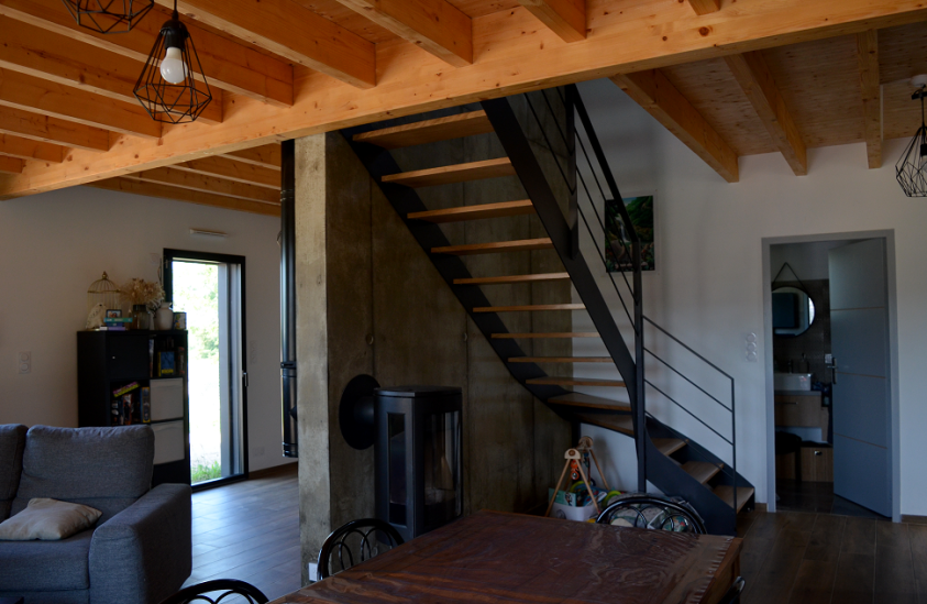 Espaces ouverts du rez-de-chaussée organisés autour du poêle à bois et des deux 