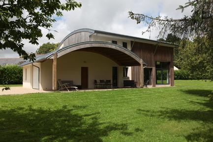 Maison bois bioclimatique, toiture cintrée en zinc à joints debouts