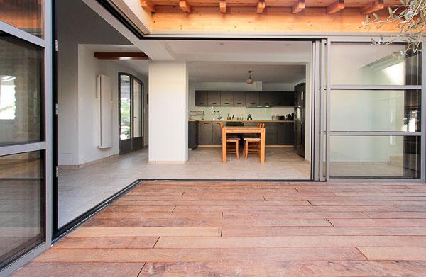 Rénovation complète d'une ferme avec création de piscine par l'Atelier S, architecte basé à Toulouse : le patio créé pour faire entrer la lumière dans la cuisine et pour connecter la maison existante  et le salon créé dans l'ancien chaix