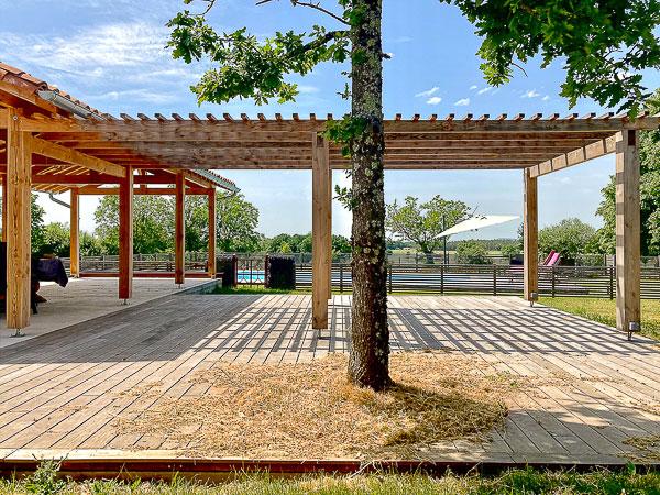 Rénovation complète d'une ferme avec création de piscine par l'Atelier S, architecte basé à Toulouse : vue de l'abri créé au bord de la piscine avec la pergola attenante pour manger à l'abri de la pluie ou du soleil 
