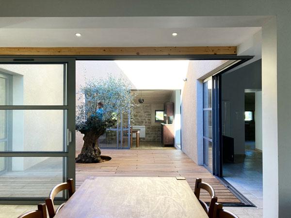 Rénovation complète d'une ferme avec création de piscine par l'Atelier S, architecte basé à Toulouse : le patio créé pour faire entrer la lumière dans la cuisine et pour connecter la maison existante  et le salon créé dans l'ancien chaix