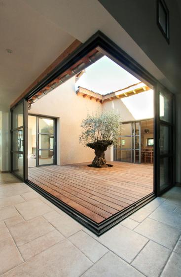 Rénovation complète d'une ferme avec création de piscine par l'Atelier S, architecte basé à Toulouse : le patio créé pour faire entrer la lumière dans la cuisine et pour connecter la maison existante  et le salon créé dans l'ancien chaix