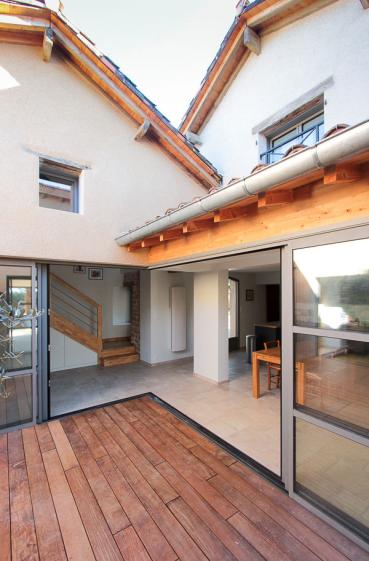 Rénovation complète d'une ferme avec création de piscine par l'Atelier S, architecte basé à Toulouse : le patio créé pour faire entrer la lumière dans la cuisine et pour connecter la maison existante  et le salon créé dans l'ancien chaix