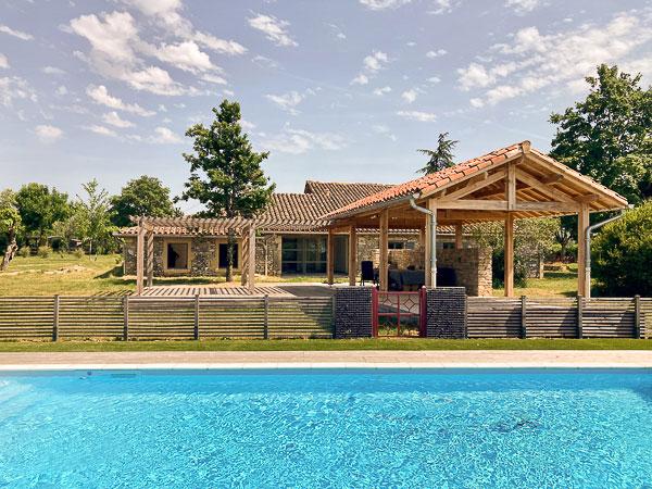 Rénovation complète d'une ferme avec création de piscine par l'Atelier S, architecte basé à Toulouse : vue de l'abri créé au bord de la piscine avec la pergola attenante pour manger à l'abri de la pluie ou du soleil 