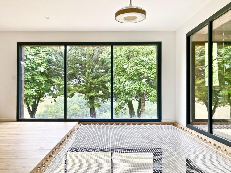 Transformation d'un hangar en maison : vue de la mezzanine avec son flet pour la sieste