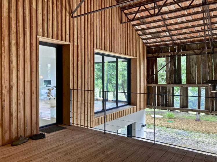 Transformation d'un hangar en maison : vue de la facade interieure en bardage bois