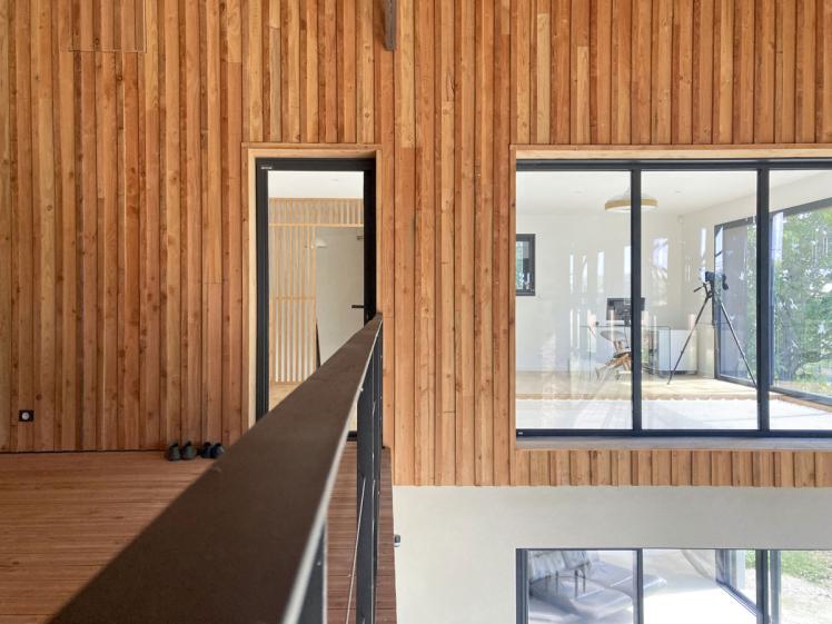 Transformation d'un hangar en maison : vue de la facade interieure en bardage bois