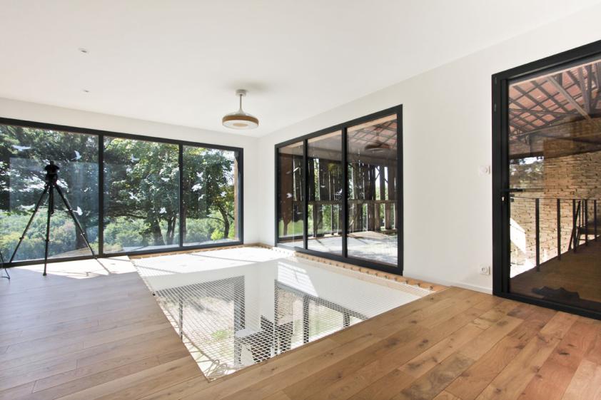 Transformation d'un hangar en maison : vue de la mezzanine avec son flet pour la sieste
