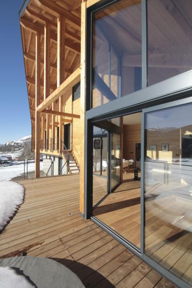 Construction d'un châlet contemporain dans les pyrénées par l'atelier S architecte à Toulouse  : la terrasse avec le bain nordique et les grandes baies  vitrées  face la montagne