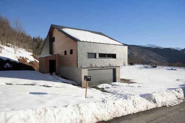 Construction d'un châlet contemporain dans les pyrénées par l'atelier S architecte à Toulouse  : intérieur avec poêle suspendu Focus coté Ouest avec le garage en sous bassement et le petit abri d'entrée