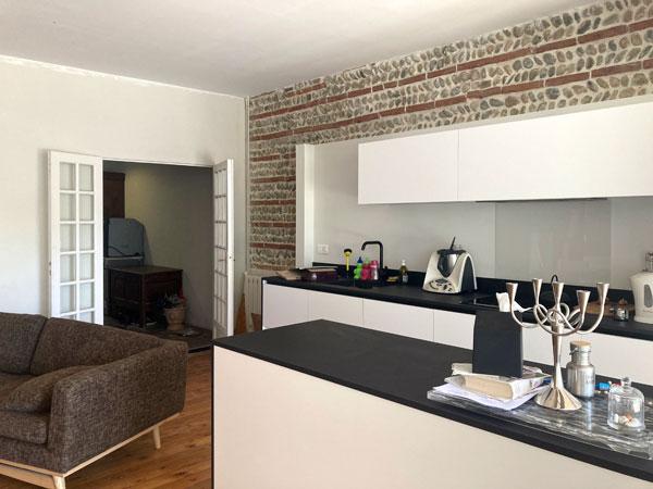 Extension et rénovation d'une maison de ville : la nouvelle cuisine avec le mur en briques restauré, projet par Atelier S architecture, architecte et architecte d'intérieur à Toulouse