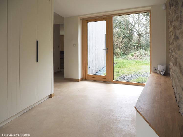Vestiaire d'entrée : mur pierre, dressing sur mesure et chape terre