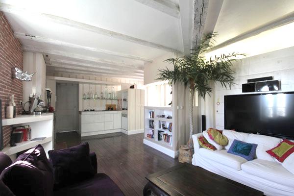 Rénovation totale d'un appartement dans le quartier Compans Cafarelli : le salon avec ses niches, le coin tv, le volume dressing qui sépare la chambre, les poutres apparentes - Projet par l'Atelier S architecte et architecte d'intérieur à Toulouse