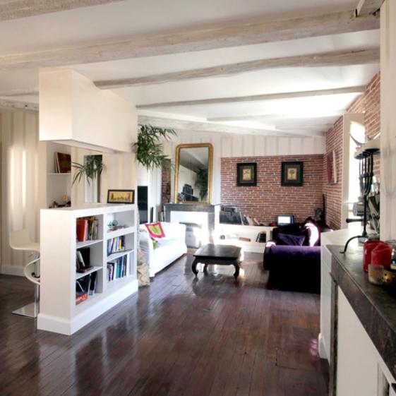 Rénovation totale d'un appartement dans le quartier Compans Cafarelli : le salon avec les briquettes conservée apparentes en fond de niche- Projet par l'Atelier S architecte et architecte d'intérieur à Toulouse