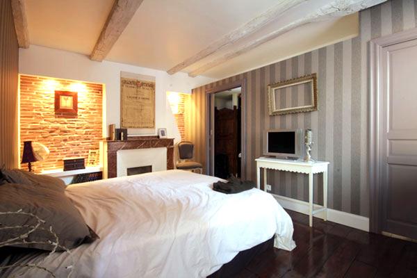 Rénovation totale d'un appartement dans le quartier Compans Cafarelli : chambre avec briques apparentes en fond de niche eteclairage indirect sur dressing -- Projet par l'Atelier S architecte et architecte d'intérieur à Toulouse
