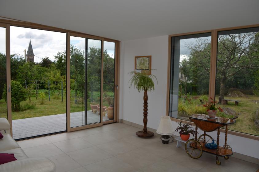 Baies vitrées ouvrant des perspectives spécifiques sur le jardin et le clocher. 