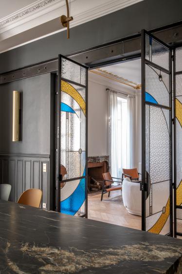 Vue de la cuisine, plan de travail sur mesure en pierre, porte sur mesure en vitrail Mobilier séléctionné