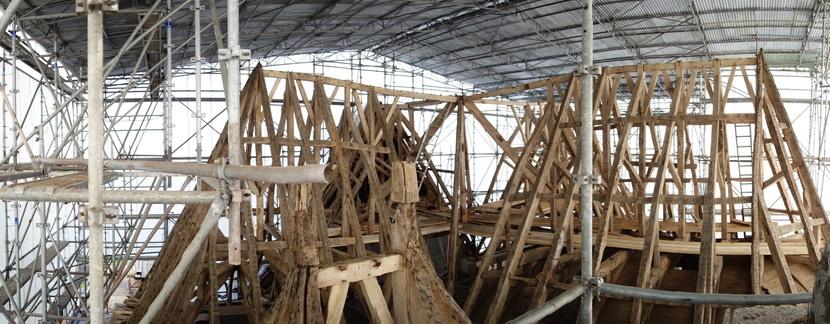charpente en cours de restauration sous parapluie 