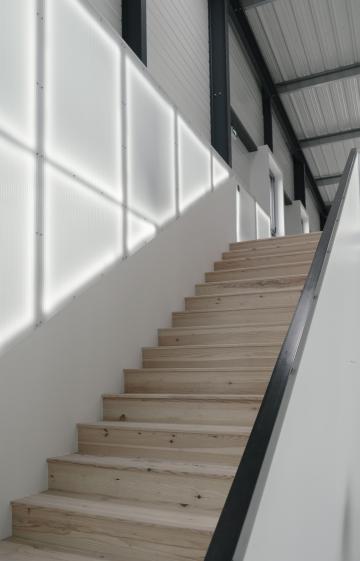 Escalier sur mesure en bois brut, aux lignes simples et naturelles.