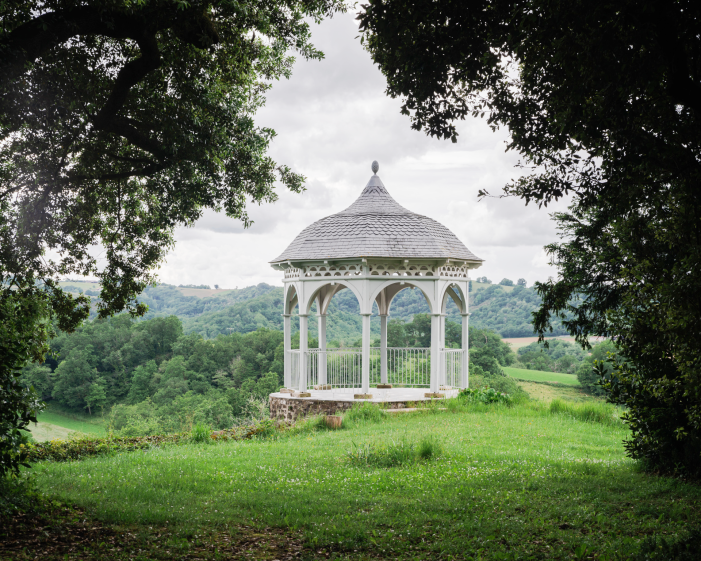 Kiosque à musique dans un parc arboré avec une couverture ardoise