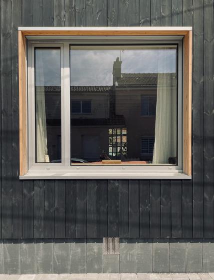 Façade avec menuiserie Façade en bardage noir, isolation en laine de bois, menuiserie aluminium et tableau en Douglas.